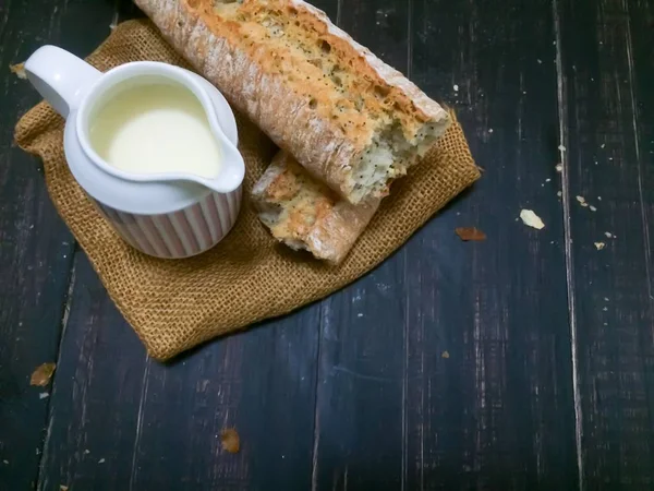 Frisches Brot auf einem Leinenstoff und einem Holztisch. — Stockfoto