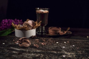 Sıcak çikolata bir bardak kupa (kakao). Keten bir peçeteye bazı macarons vardır 