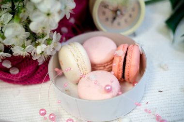 Beyaz bir yığın ve saatler beyaz zemin üzerine ihale macaroons