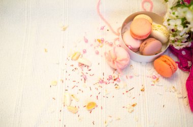 İhale pastel pembe ve turuncu macaroons beyaz battaniye ve arka plan
