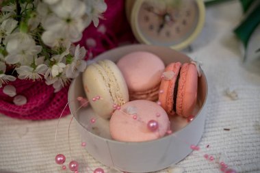 Beyaz bir yığın ve saatler beyaz zemin üzerine ihale macaroons