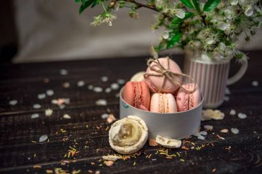 Beyaz kiraz çiçekleri ve macaroons beyaz tabak içinde bir dalı ile sürahi