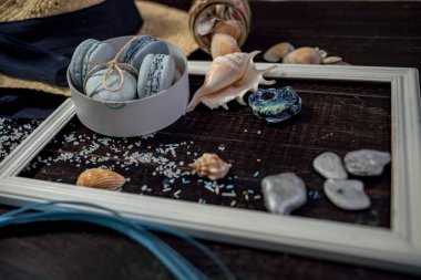 Mavi macaroons ve ahşap zemin üzerine kabukları ile deniz tuzu ile hasır şapka