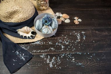 Mavi macaroons ve ahşap zemin üzerine kabukları ile deniz tuzu ile hasır şapka