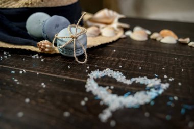 Mavi macaroons ve ahşap zemin üzerine kabukları ile deniz tuzu ile hasır şapka