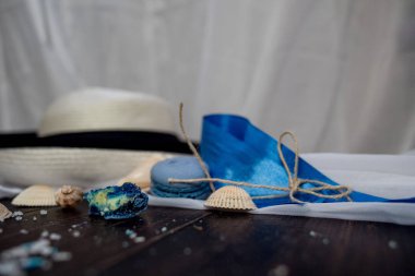 Mavi macaroons ve ahşap zemin üzerine kabukları ile deniz tuzu ile hasır şapka