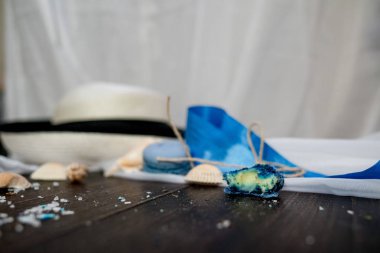 Mavi macaroons ve ahşap zemin üzerine kabukları ile deniz tuzu ile hasır şapka