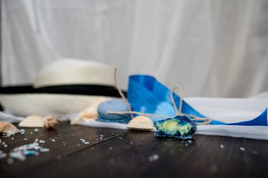 Mavi macaroons ve ahşap zemin üzerine kabukları ile deniz tuzu ile hasır şapka