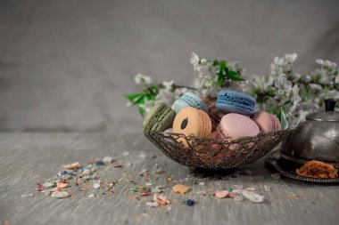 Doğu vazo bir masada çok renkli macaroons