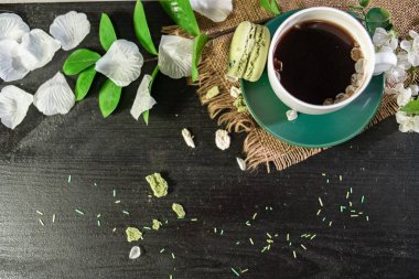 Bir fincan kahve çiçek kiraz ve monstera yaprak dalı ile beyaz bir tepsi