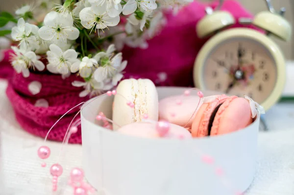 Tender macaroons in a white pile and clocks on white background — Stock Photo, Image