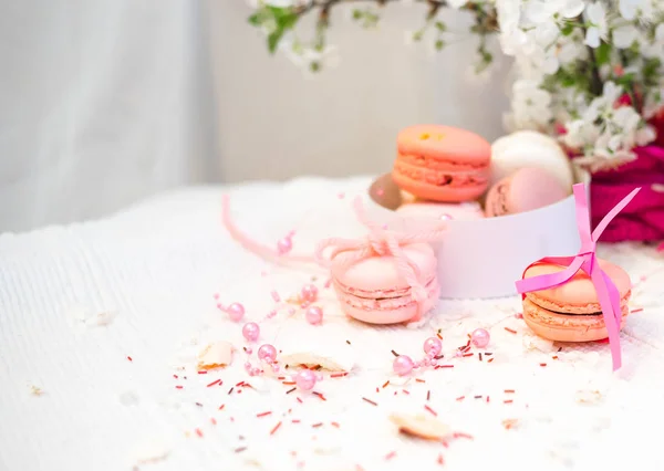 Macarrones tiernos de color rosa pastel y naranja sobre una manta blanca y fondo —  Fotos de Stock