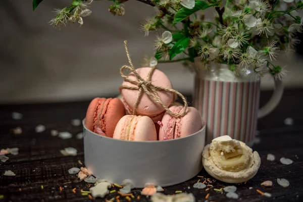 Jarra blanca con una rama de flores de cerezo y macarrones en un plato blanco profundo —  Fotos de Stock