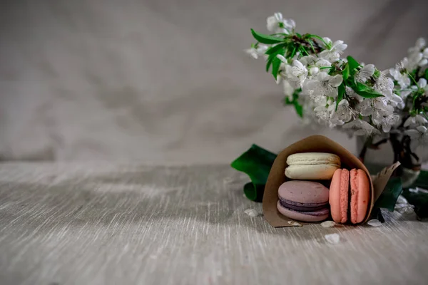 Macarons multicolores dans un vase en métal argenté sur fond pastel avec boisson au cacao chaud — Photo
