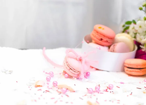 Macarrones tiernos de color rosa pastel y naranja sobre una manta blanca y fondo —  Fotos de Stock