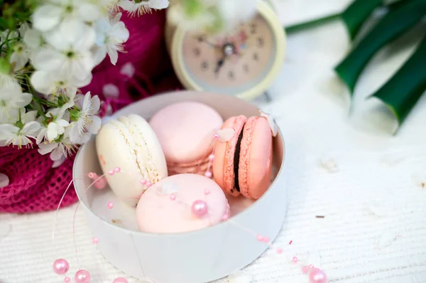 Macarrones tiernos en una pila blanca y relojes sobre fondo blanco —  Fotos de Stock