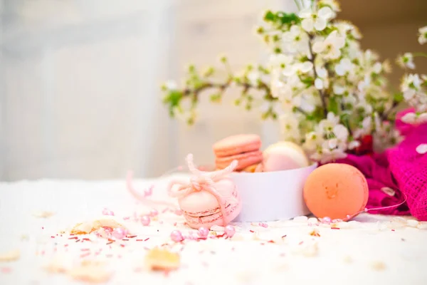 Tender pastel pink and orange macaroons on a white blanket and background — Stock Photo, Image