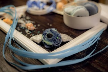 Deniz orada eski bir ahşap masa üzerinde mavi ve deniz mavi macaroons