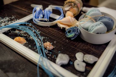 Deniz orada eski bir ahşap masa üzerinde mavi ve deniz mavi macaroons