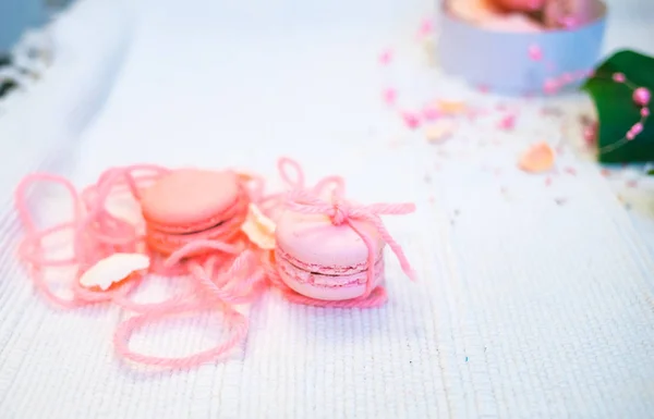 Tender pastel pink and orange macaroons on a white blanket and background — Stock Photo, Image