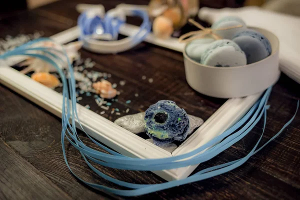 Deniz orada eski bir ahşap masa üzerinde mavi ve deniz mavi macaroons