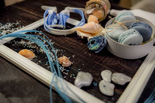 Deniz orada eski bir ahşap masa üzerinde mavi ve deniz mavi macaroons