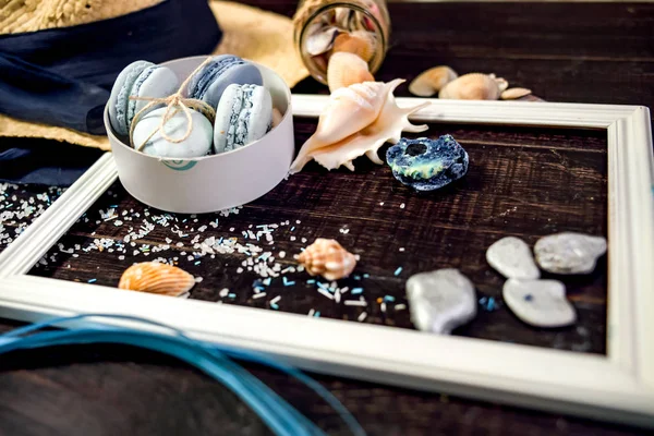 Deniz orada eski bir ahşap masa üzerinde mavi ve deniz mavi macaroons