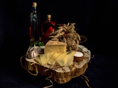 Kraft ahşap masa üzerinde şişe ile sebze ile koyu arka plan üzerinde ev yapımı peynir