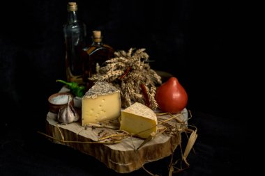 Kraft ahşap masa üzerinde şişe ile sebze ile koyu arka plan üzerinde ev yapımı peynir