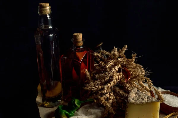 Ahşap masa üzerinde şişe ile sebze ile koyu arka plan üzerinde ev yapımı peynir