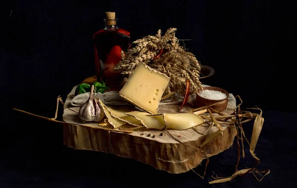 Queijo caseiro Kraft no fundo escuro com legumes com garrafas na mesa de madeira — Fotografia de Stock