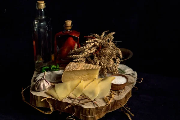 Queijo caseiro Kraft no fundo escuro com legumes com garrafas na mesa de madeira — Fotografia de Stock