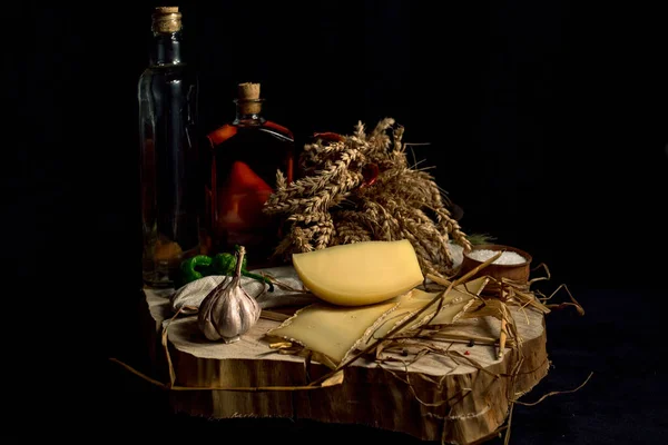 Queijo caseiro Kraft no fundo escuro com legumes com garrafas na mesa de madeira — Fotografia de Stock