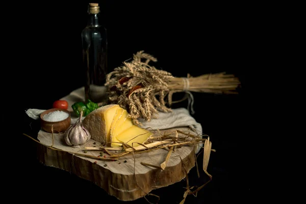 Queijo caseiro Kraft no fundo escuro com legumes com garrafas na mesa de madeira — Fotografia de Stock