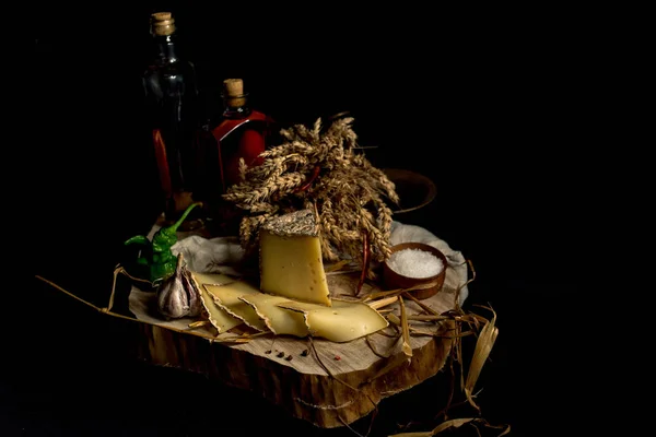 Kraft homemade cheese on the dark background with vegetables with bottles on wood table — Stock Photo, Image