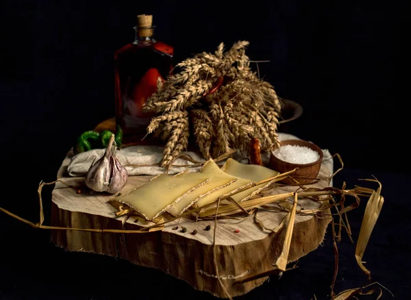 Queijo caseiro Kraft no fundo escuro com legumes com garrafas na mesa de madeira — Fotografia de Stock