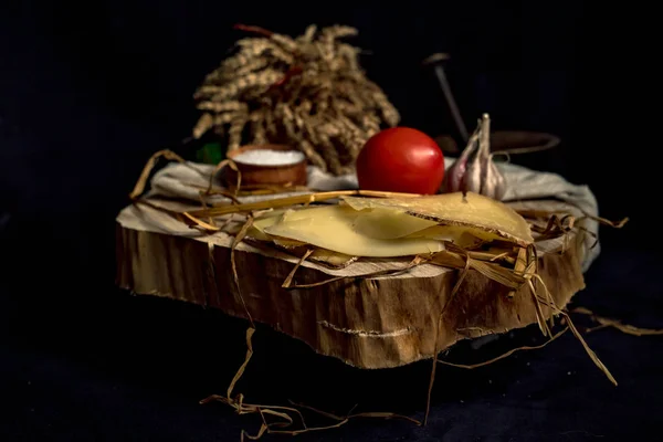 Queijo artesanal fatiado em uma tábua de madeira — Fotografia de Stock