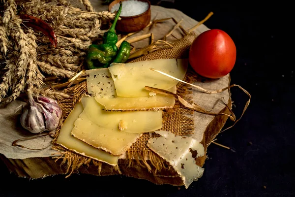 Sliced handmade cheese on a wood board — Stock Photo, Image