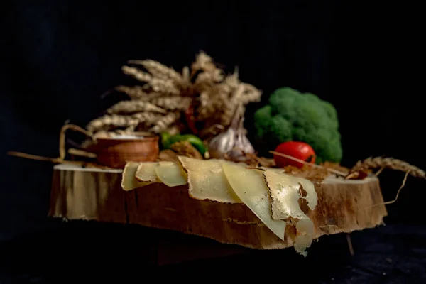 Queijo artesanal fatiado em uma tábua de madeira — Fotografia de Stock