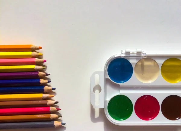Многоцветные карандаши и краски — стоковое фото