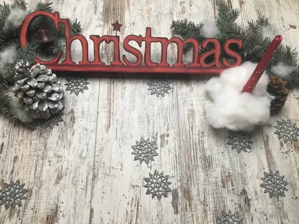 Christmas red logo letters on a old wood background with red candle in snow-ball
