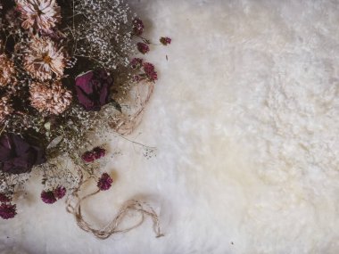 Kuru çiçekler, yün bir iple.