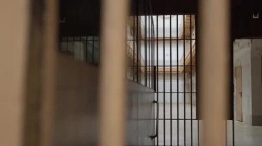 Hapishane koridorunun parmaklıklar ardındaki görüntüsü.