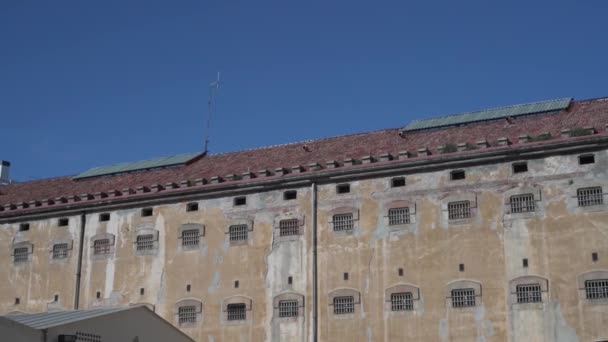 Panoramatický pohled na vězeňskou budovu s okny vězeňských cel s kovovými mřížemi — Stock video