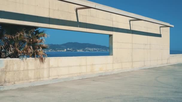 Море с чистой водой и морским побережьем, вид через бетонное окно . — стоковое видео