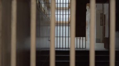 prison corridor, view through metal bars