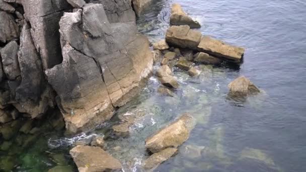 Rocce e pietre sulla costa oceanica. onde dell'oceano battono contro le rocce — Video Stock