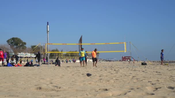 La gente juega voleibol de playa en la playa Nova Ikaria de Barcelona, tiempo soleado — Vídeos de Stock