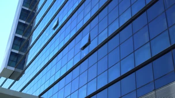 Fachada de cristal de un edificio de oficinas en tiempo soleado — Vídeo de stock