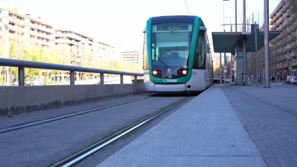 Die Straßenbahn verlässt die Haltestelle und fährt in der Nähe der Kamera vorbei. Grüne Straßenbahn — Stockvideo
